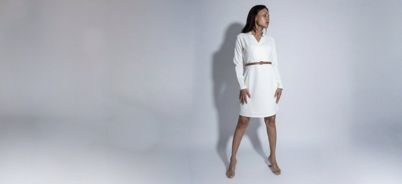 Woman wearing a white dress on a plain background