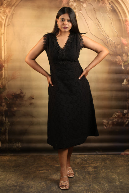 Woman wearing a black cotton midi dress with lace details