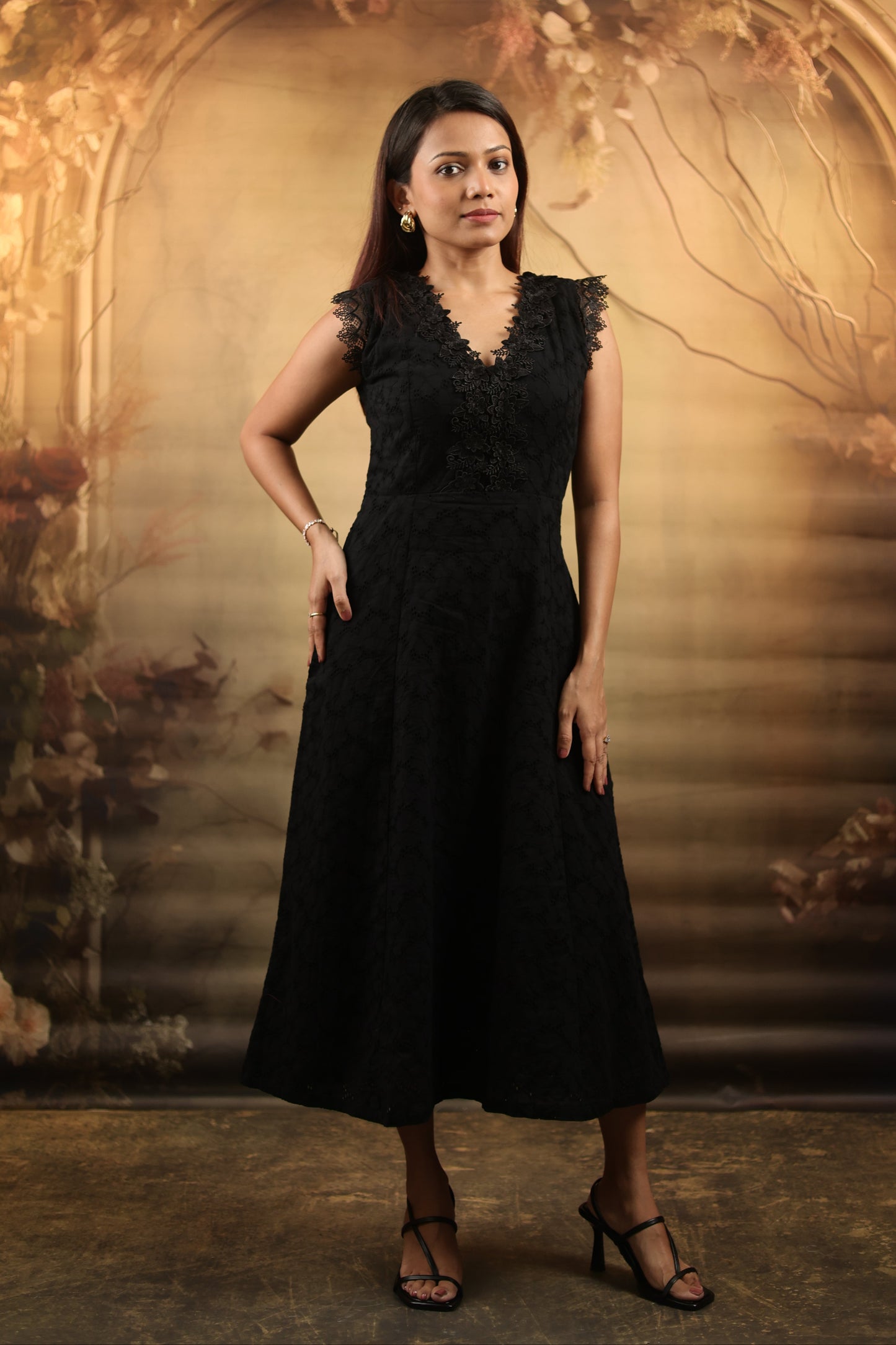 Woman wearing a black petite midi dress with lace
