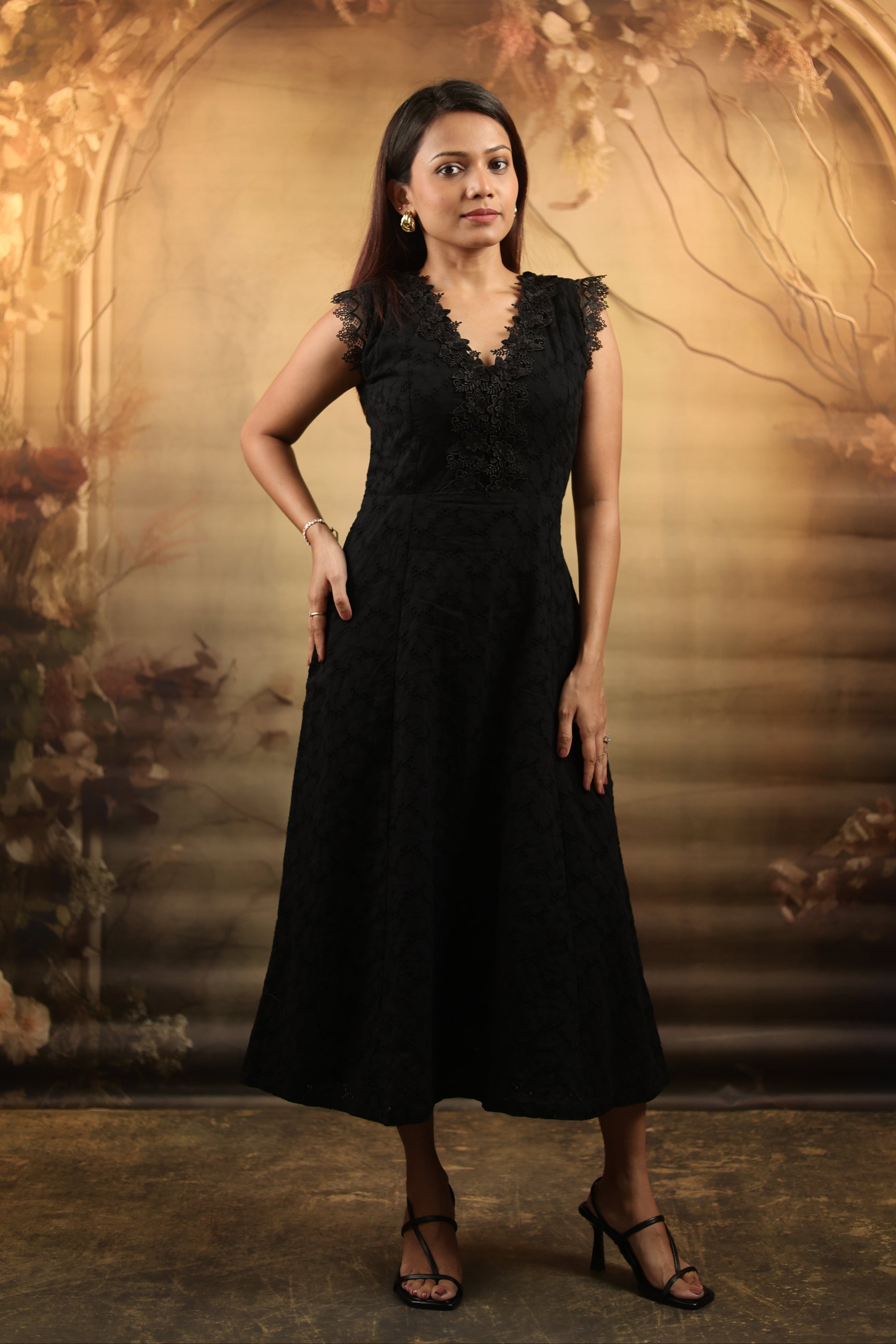Woman wearing a black petite midi dress with lace