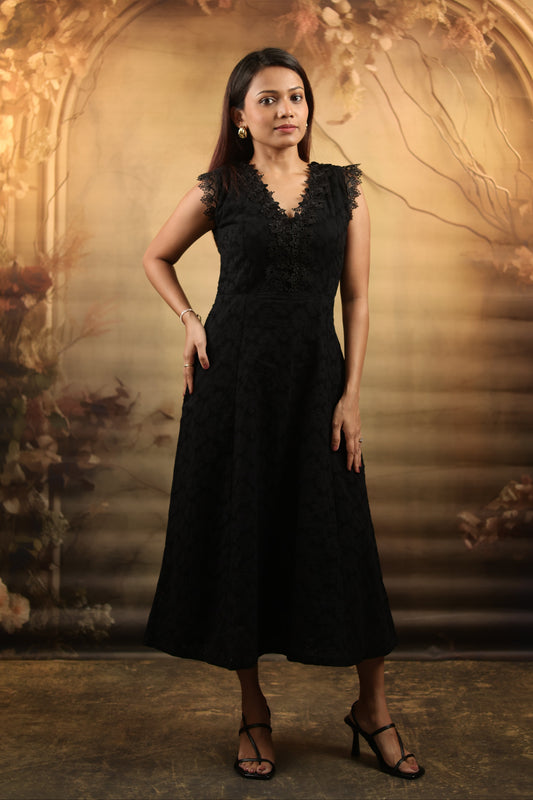 Woman wearing a black petite midi dress with lace